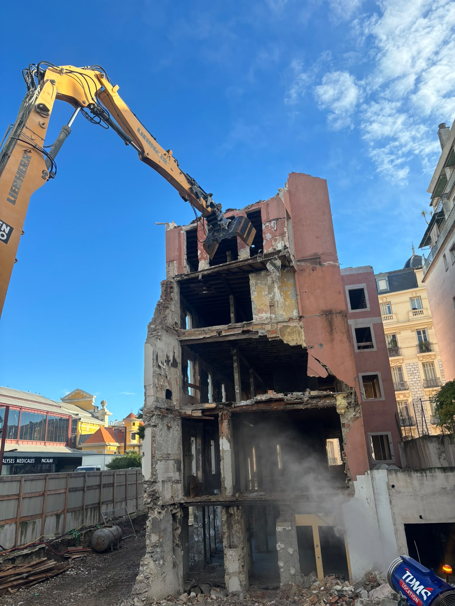 Pelle équipée d'une pince de démolition sur une structure maçonnée